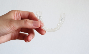 手にマウスピースを持っている